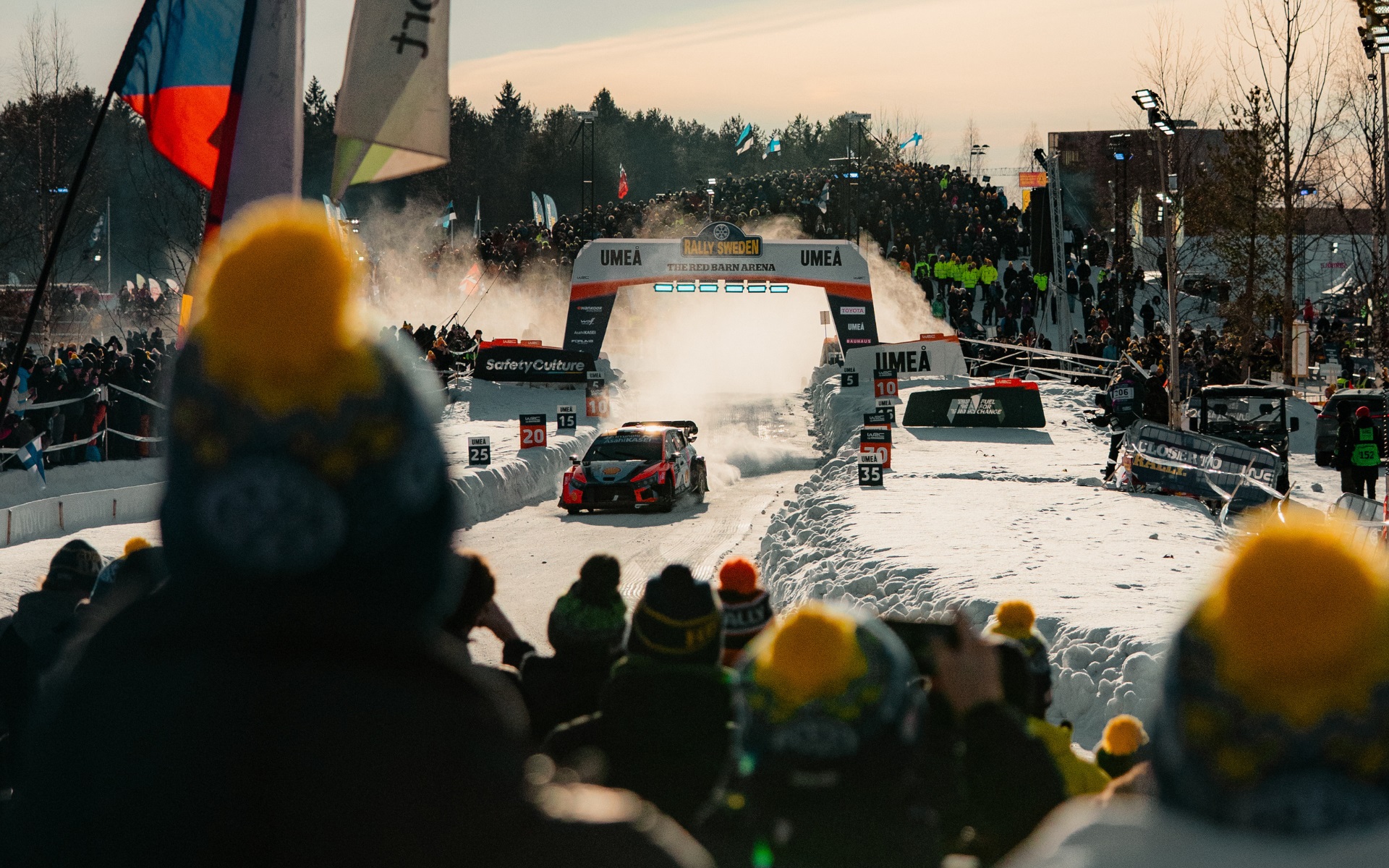 Rallybilar och folksamling