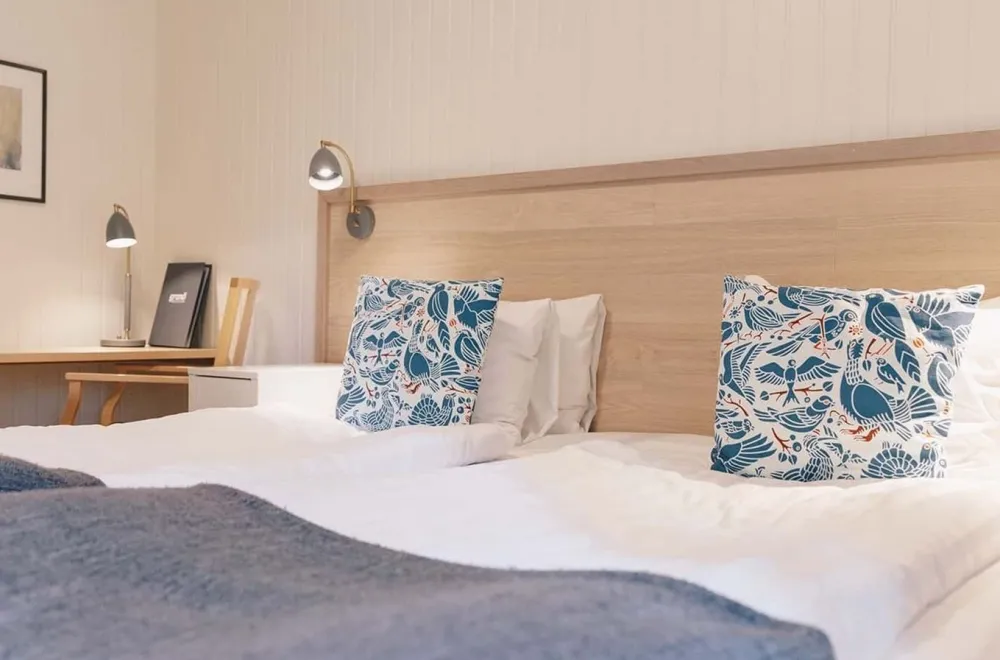 hotellsäng bäddat med vita linnelakan