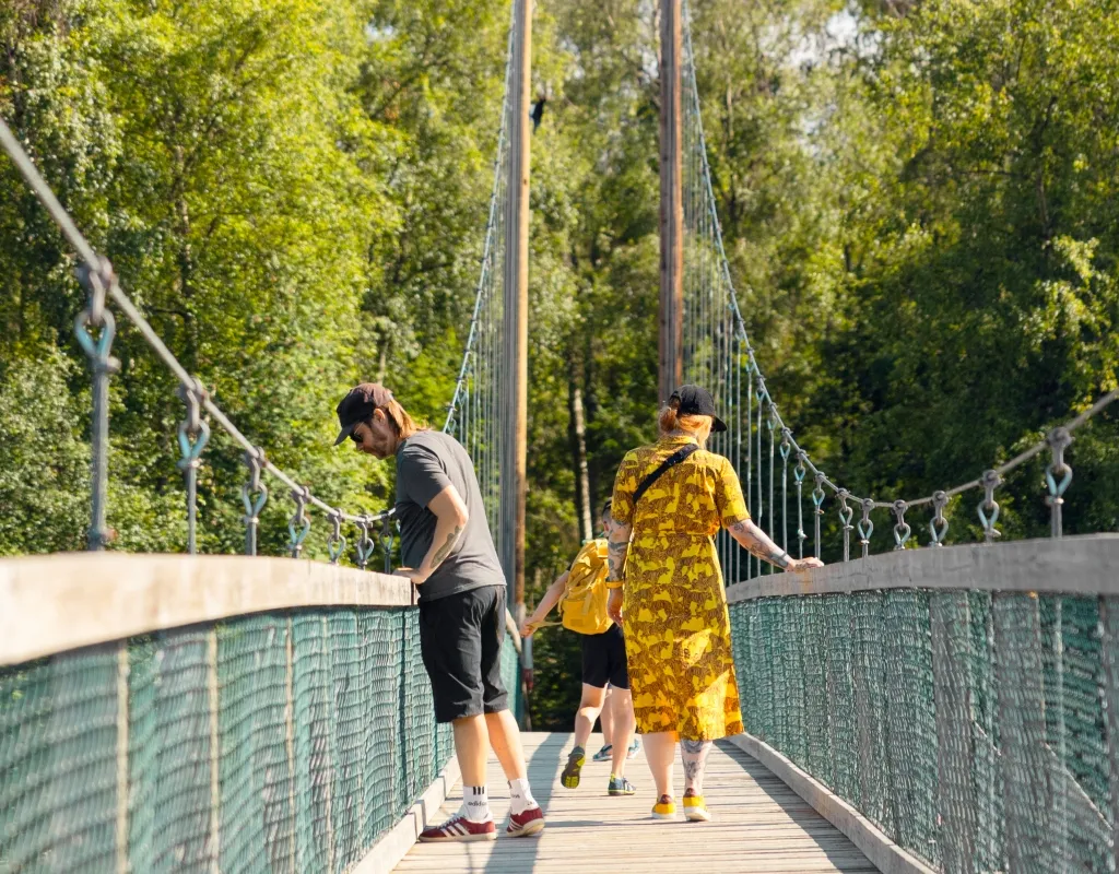 Personer går över hängbron till Stora Tuvan 